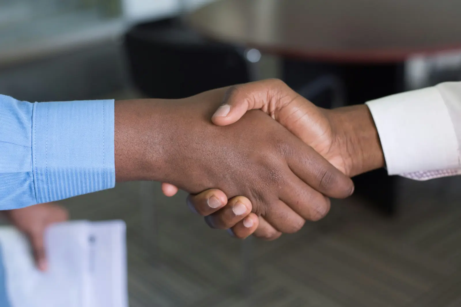 Business partners reviewing procurement contracts at a meeting table